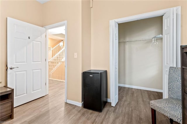 interior space featuring light hardwood / wood-style floors, black refrigerator, and a closet