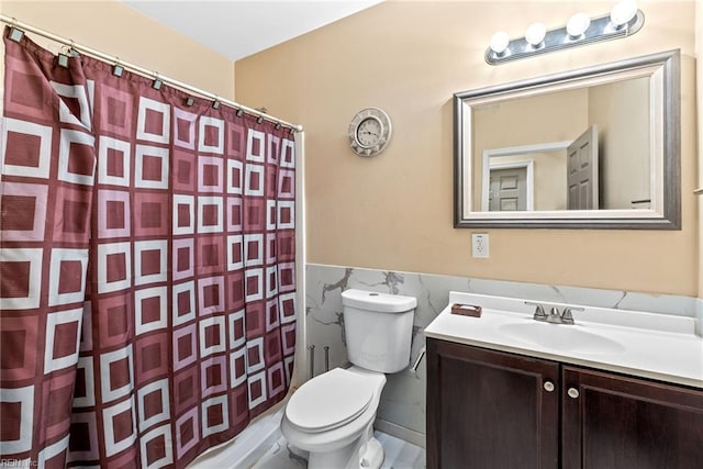 bathroom with vanity, curtained shower, toilet, and tile walls