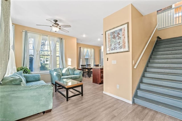 living room with ceiling fan and light hardwood / wood-style flooring