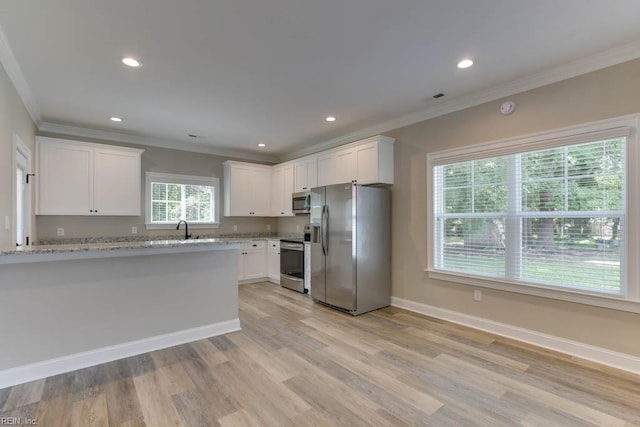 kitchen with light stone countertops, white cabinets, light wood-type flooring, and appliances with stainless steel finishes