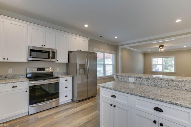 kitchen featuring light wood-type flooring, ornamental molding, stainless steel appliances, ceiling fan, and white cabinetry