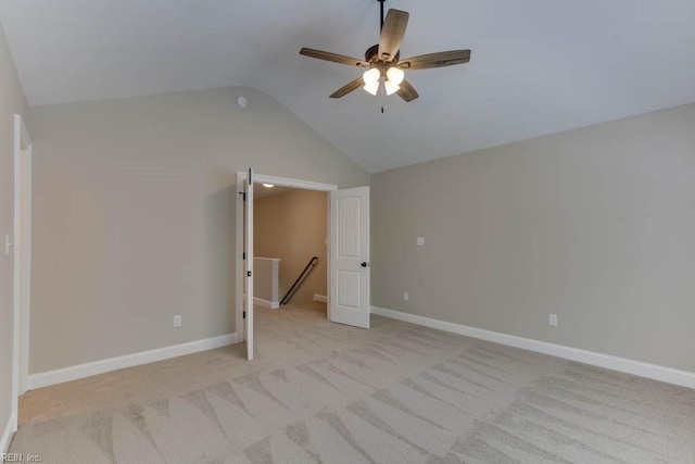 unfurnished bedroom featuring ceiling fan, light colored carpet, and vaulted ceiling