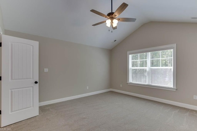 carpeted spare room featuring ceiling fan and vaulted ceiling