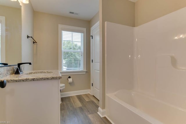 full bathroom featuring wood-type flooring, vanity, toilet, and tub / shower combination