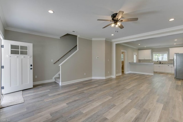 foyer featuring ceiling fan, sink, light wood-type flooring, and crown molding