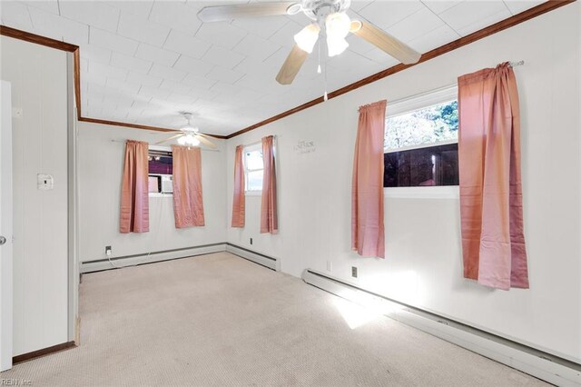 carpeted spare room with ceiling fan, plenty of natural light, ornamental molding, and a baseboard heating unit