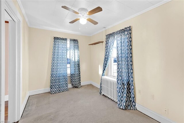 spare room featuring radiator, ornamental molding, and ceiling fan