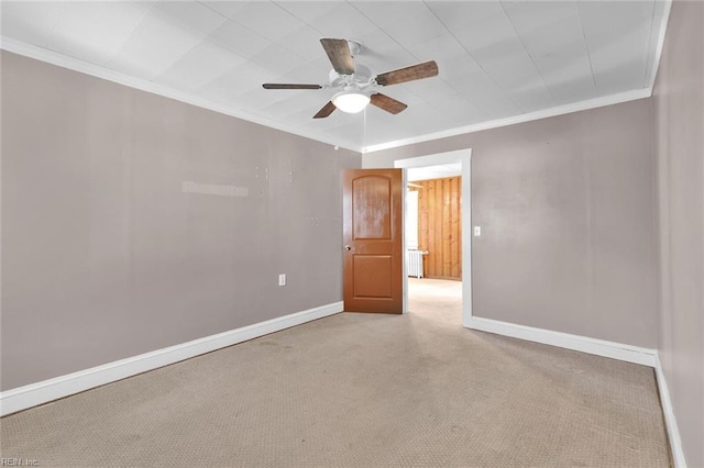 unfurnished room with ceiling fan, ornamental molding, and light carpet