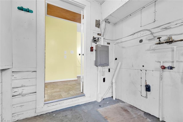 misc room with electric panel and concrete floors