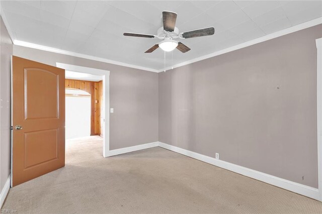 spare room with light colored carpet, ceiling fan, and crown molding