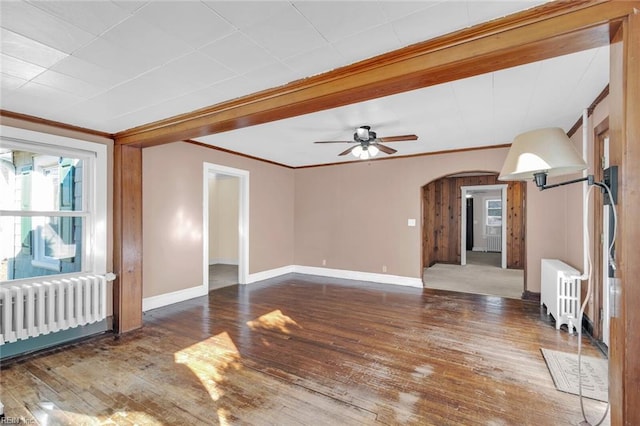 spare room with radiator, ceiling fan, dark hardwood / wood-style floors, and ornamental molding