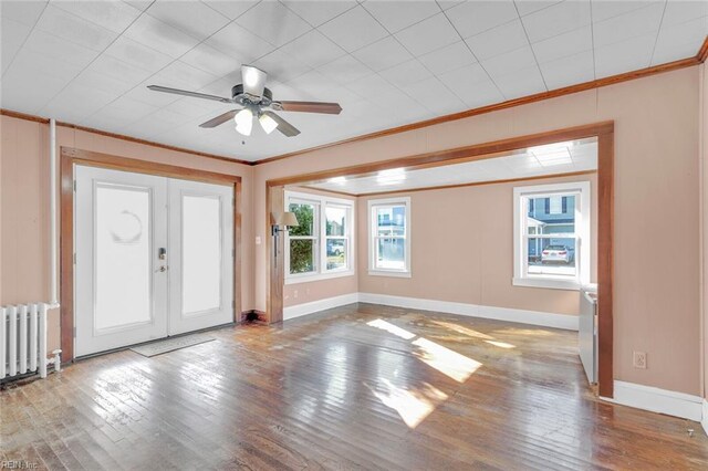 unfurnished living room with radiator, ceiling fan, light wood-type flooring, and ornamental molding