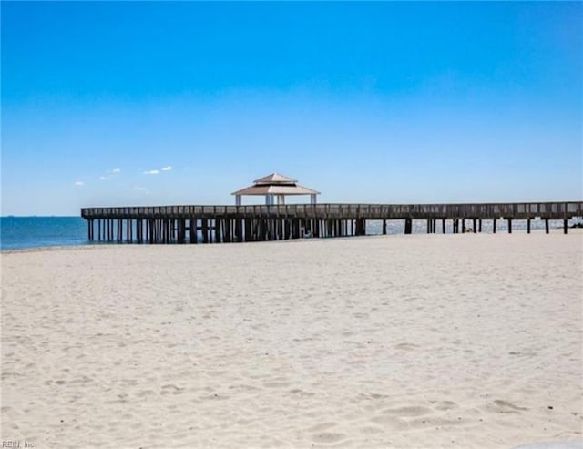 surrounding community with a beach view and a water view