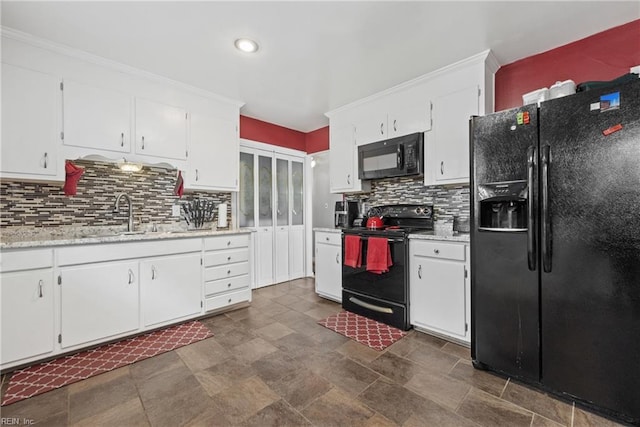 kitchen featuring sink, white cabinetry, and black appliances