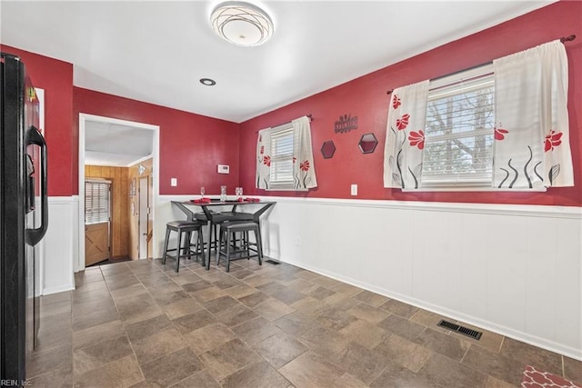 dining space featuring wood walls