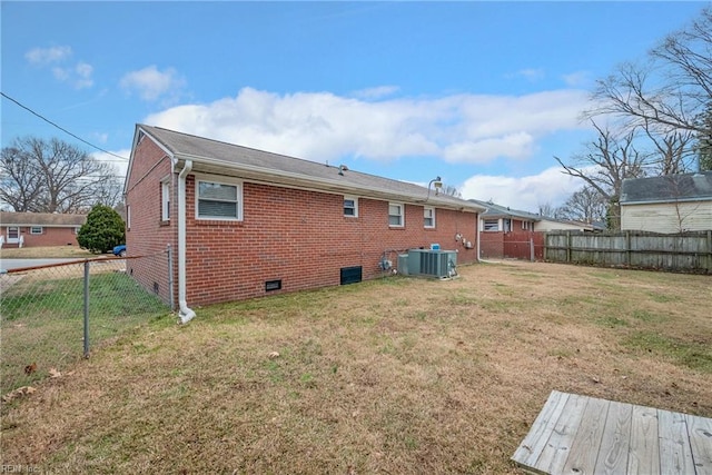 rear view of house with a lawn and cooling unit