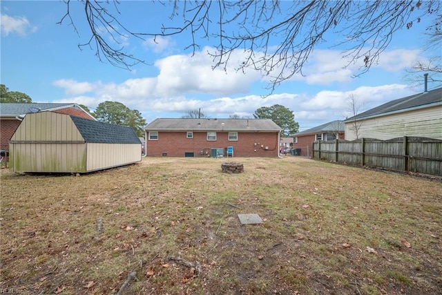 back of house featuring a storage unit and a lawn