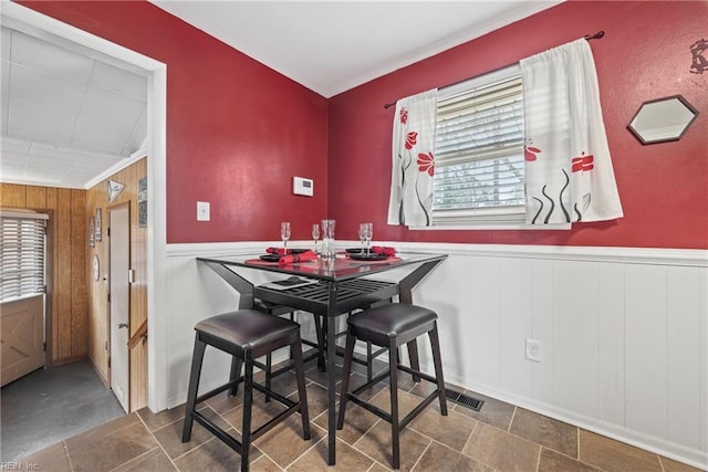 dining space featuring a wealth of natural light and wooden walls