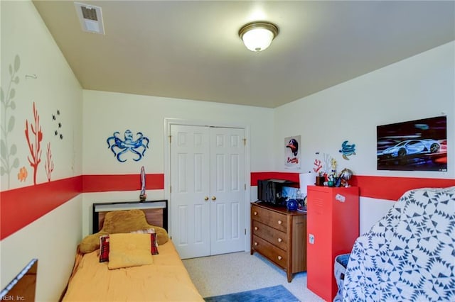 bedroom featuring light colored carpet and a closet