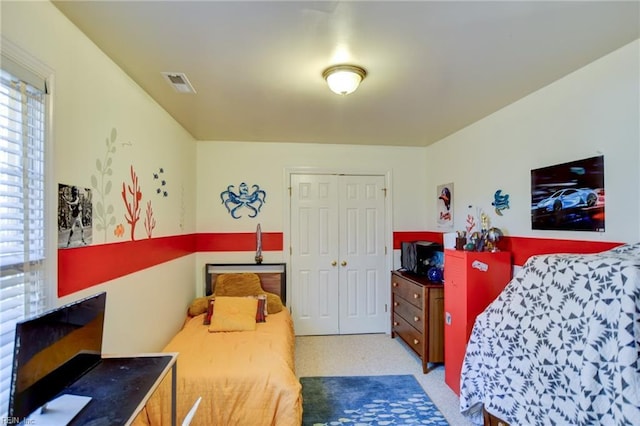 bedroom featuring light carpet and a closet