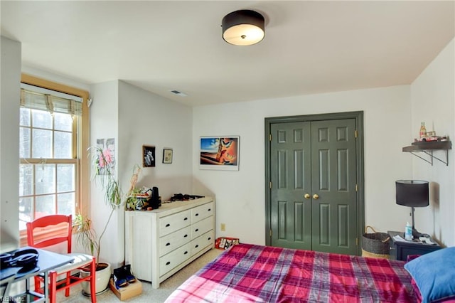 bedroom featuring light carpet and a closet