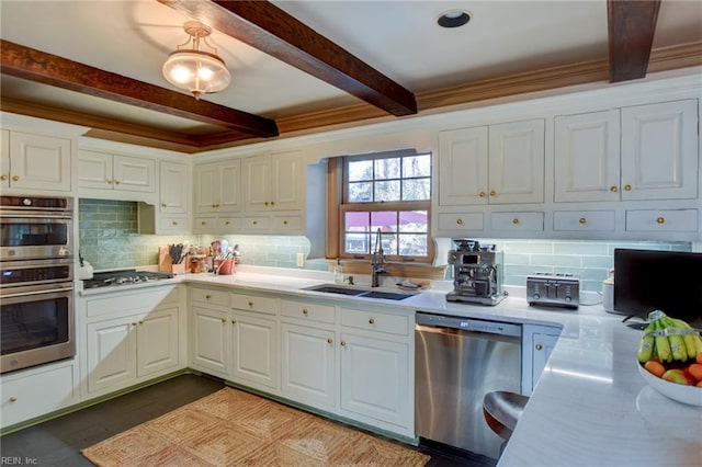 kitchen featuring white cabinets, appliances with stainless steel finishes, tasteful backsplash, and sink