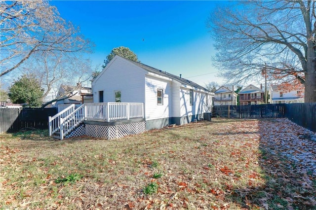 back of house featuring a deck and a lawn