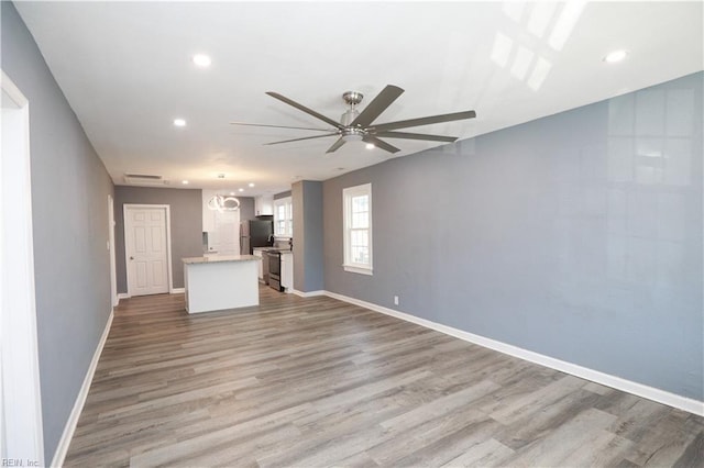 unfurnished living room with hardwood / wood-style flooring and ceiling fan