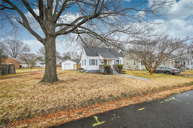 view of front of house with an outbuilding, a front yard, and a garage