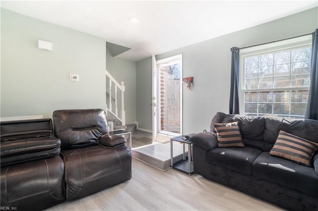 living room with light hardwood / wood-style floors and a healthy amount of sunlight