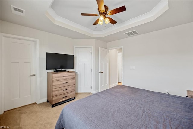 bedroom featuring ceiling fan, light carpet, and a tray ceiling