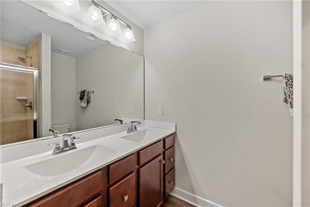 bathroom with vanity, an enclosed shower, and toilet