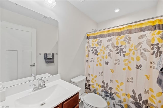 bathroom featuring a shower with shower curtain, vanity, and toilet