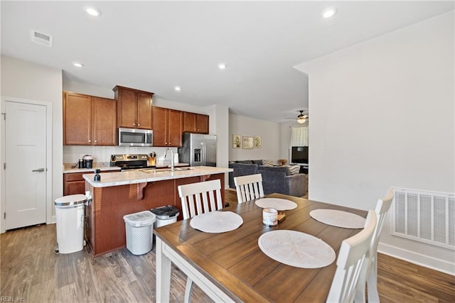 dining space featuring ceiling fan, dark wood-type flooring, and sink