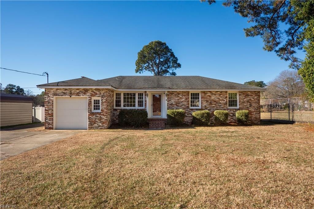 single story home with a front yard and a garage