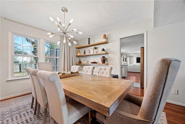 dining space featuring a textured ceiling, dark hardwood / wood-style floors, and an inviting chandelier