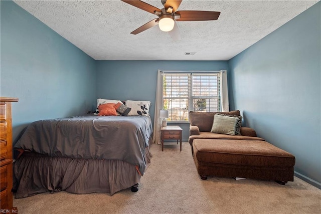 bedroom featuring ceiling fan, a textured ceiling, and light carpet