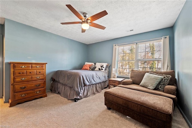 carpeted bedroom featuring a textured ceiling and ceiling fan