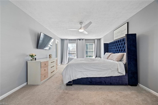 bedroom featuring a textured ceiling, ceiling fan, and light carpet