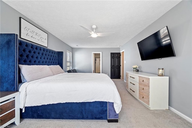 bedroom featuring ceiling fan, light colored carpet, and a textured ceiling