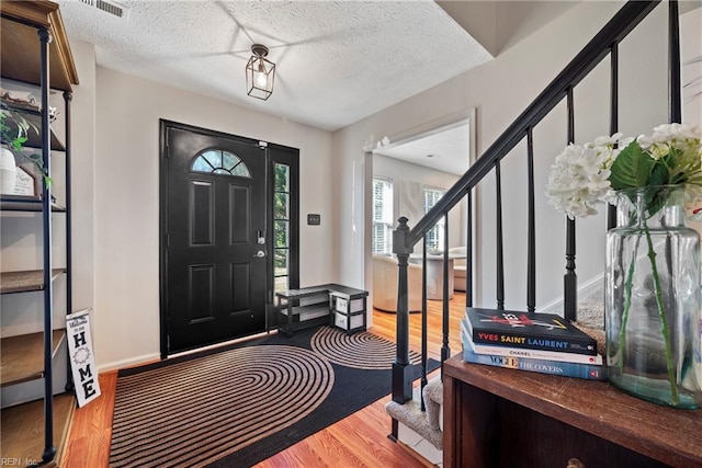 entryway with light hardwood / wood-style flooring and a textured ceiling