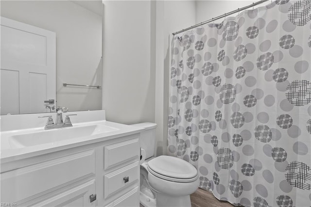 bathroom featuring hardwood / wood-style floors, vanity, curtained shower, and toilet