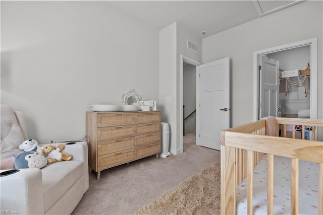 bedroom featuring light carpet and a nursery area