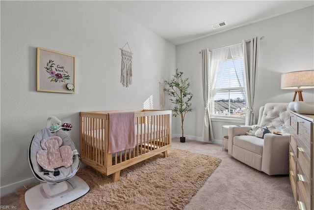 bedroom featuring light carpet and a crib