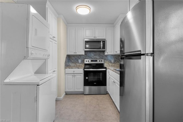 kitchen featuring white cabinets, light tile patterned floors, tasteful backsplash, stacked washer / drying machine, and stainless steel appliances