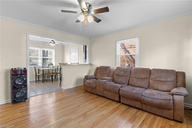 living room featuring crown molding, light hardwood / wood-style flooring, and ceiling fan