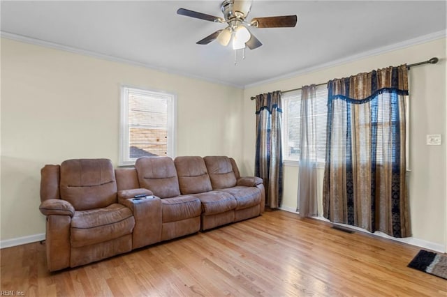 living room with light hardwood / wood-style floors, plenty of natural light, ceiling fan, and ornamental molding