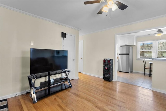 living room with ceiling fan, light wood-type flooring, and ornamental molding