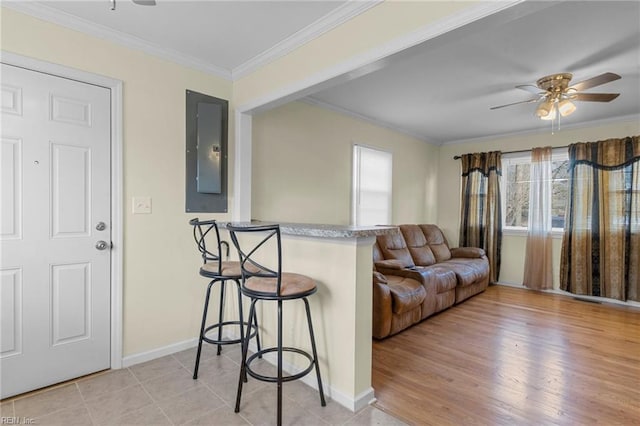 living room featuring electric panel, crown molding, light hardwood / wood-style flooring, and ceiling fan