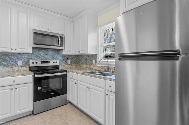 kitchen featuring backsplash, white cabinets, sink, light tile patterned floors, and appliances with stainless steel finishes